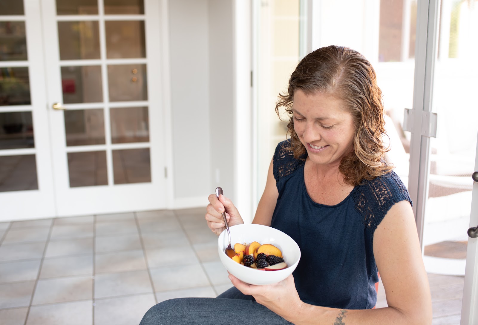 Client smiling with a nourishing bowl