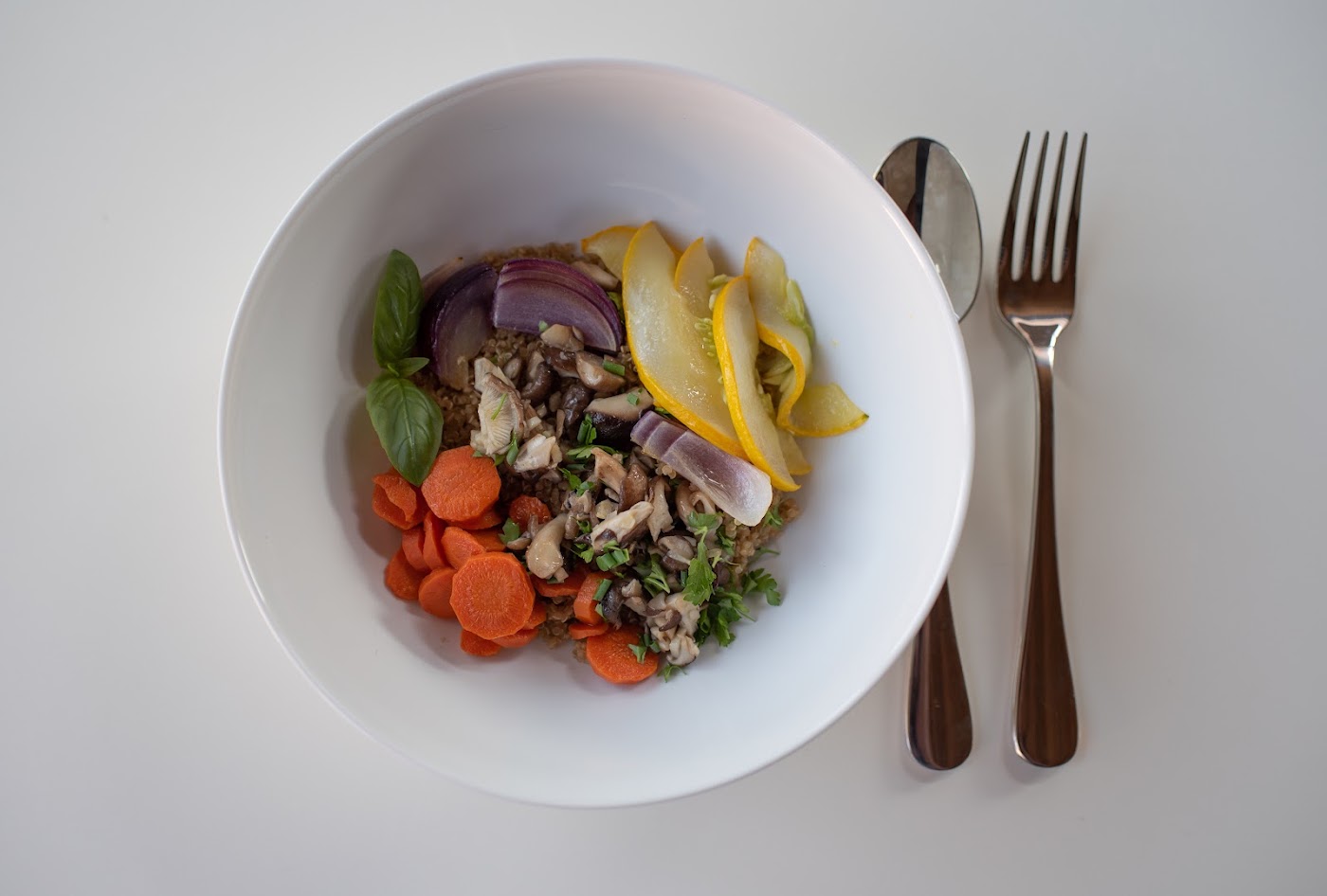 Nourishing bowl with roasted vegetables, carrots, and fresh herbs
